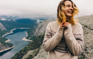 Girl standing on the Trolltunga and laughing