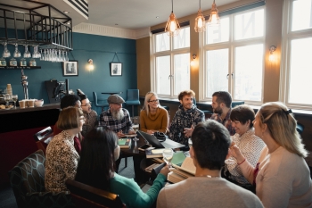 group of people sitting in a circle with books in front of them