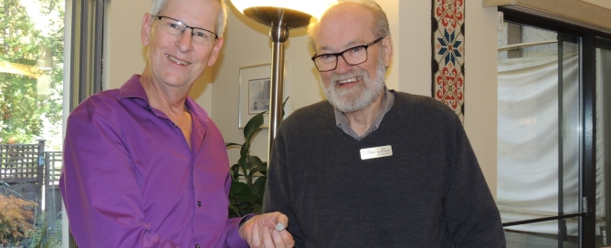Ron Stubbings receives a pin from Erik Brochmann for his contribution to the Sons of Norway Foundation in Canada