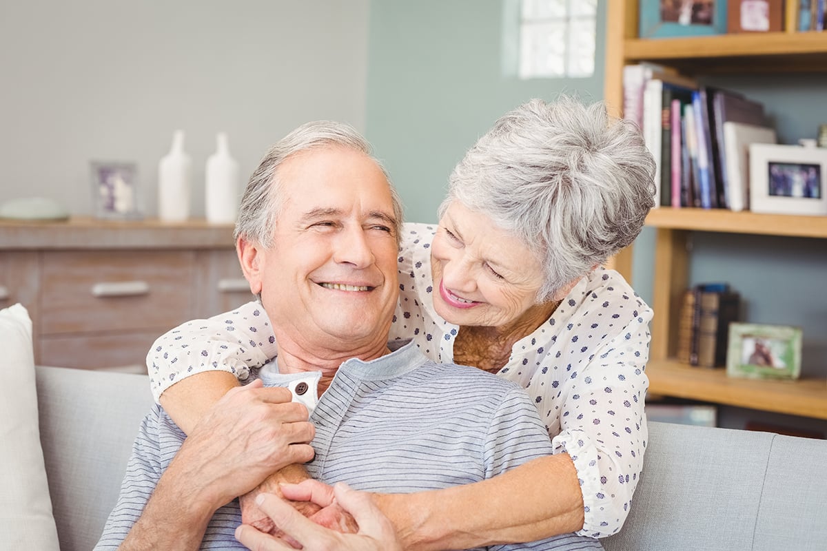 Happy couple embracing at home