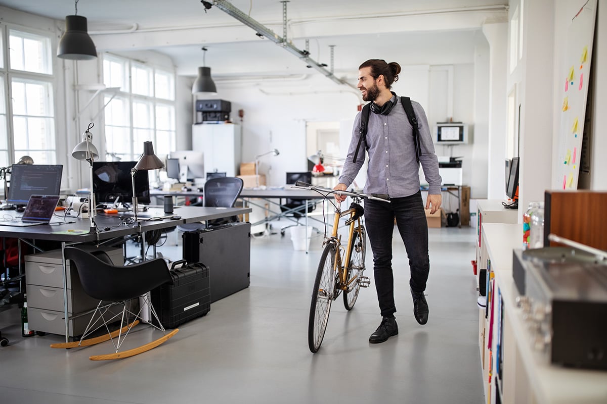 Businessman with a bicycle in office. Business professional going home after work.