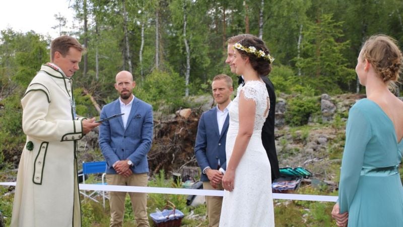 bride and groom standing at the border between Norway and Sweden