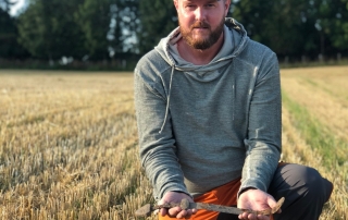 man holding a sword in a field