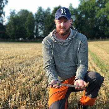 man holding a sword in a field